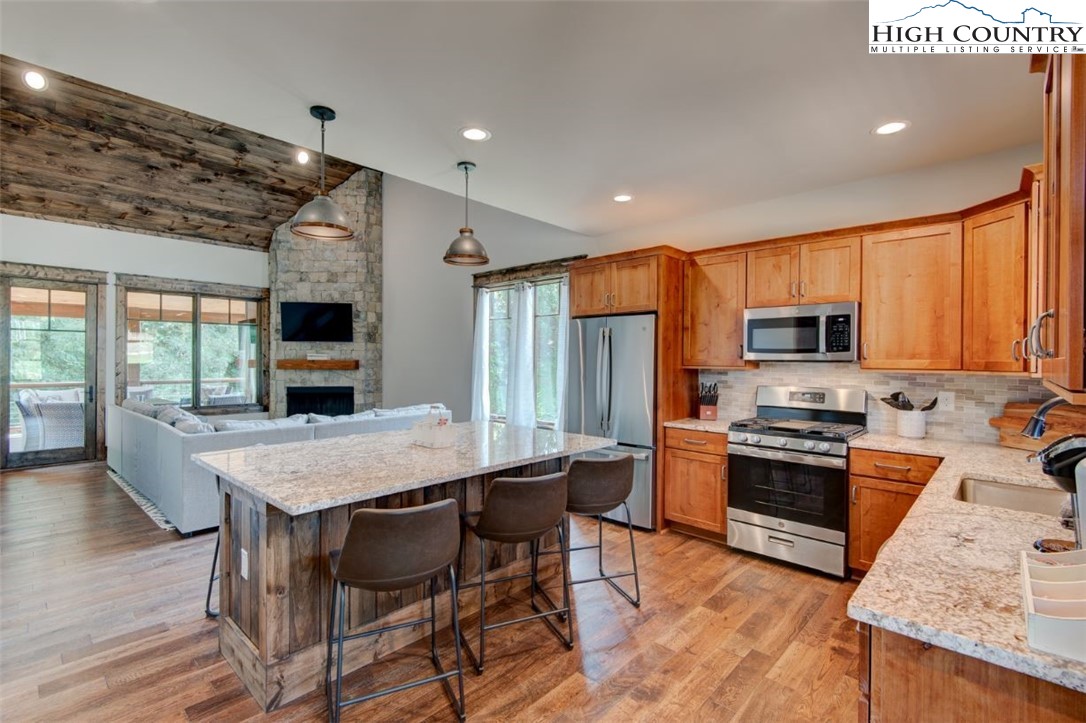 273 High Country Overlook Banner Elk, NC 28604 - Photo 11 of 50 a kitchen with stainless steel appliances granite countertop a stove top oven a sink dishwasher a dining table and chairs with wooden floor