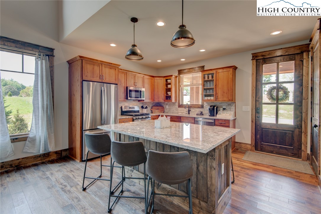 273 High Country Overlook Banner Elk, NC 28604 - Photo 24 of 50 a kitchen with stainless steel appliances granite countertop a refrigerator a sink dishwasher a stove and a dining table with wooden floor