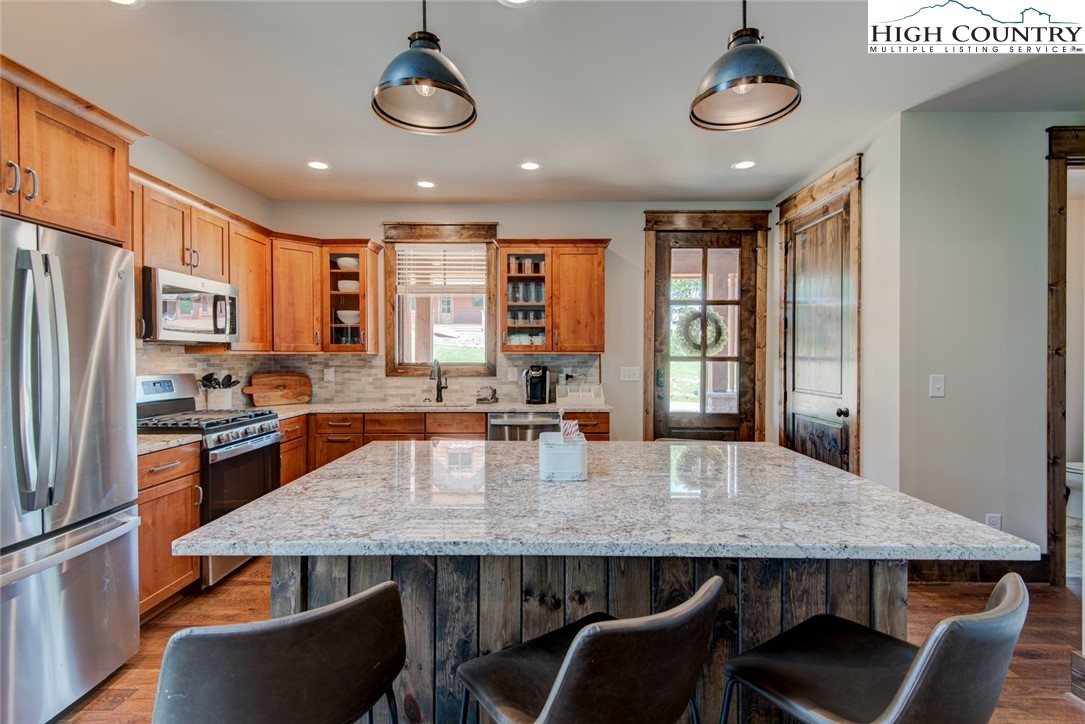 273 High Country Overlook Banner Elk, NC 28604 - Photo 25 of 50 a kitchen with stainless steel appliances granite countertop a dining table chairs stove refrigerator and cabinets