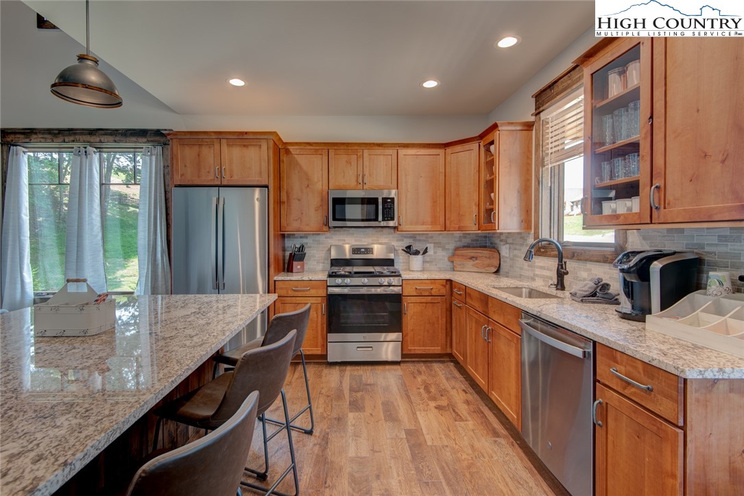 273 High Country Overlook Banner Elk, NC 28604 - Photo 28 of 50 a kitchen with granite countertop a stove top oven a sink dishwasher a dining table and chairs with wooden floor