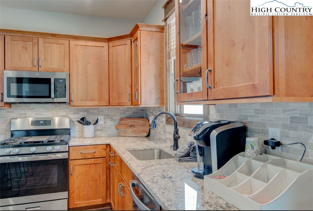 273 High Country Overlook Banner Elk, NC 28604 - Photo 10 of 50 a kitchen with stainless steel appliances granite countertop a sink stove and microwave