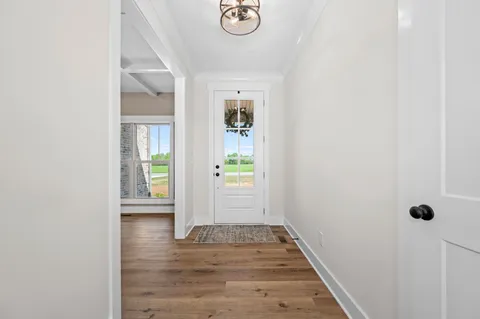 an empty room with wooden floor fireplace and windows
