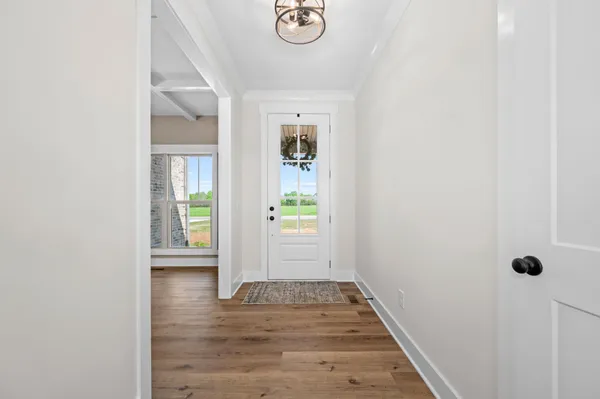 an empty room with wooden floor fireplace and windows