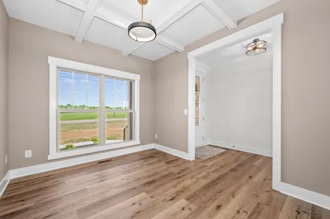 a view of empty room with wooden floor and fireplace
