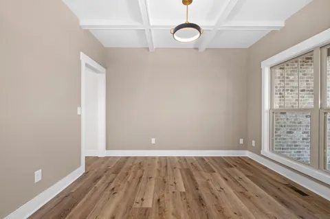 a dining room with wooden floor a chandelier a wooden table and chairs