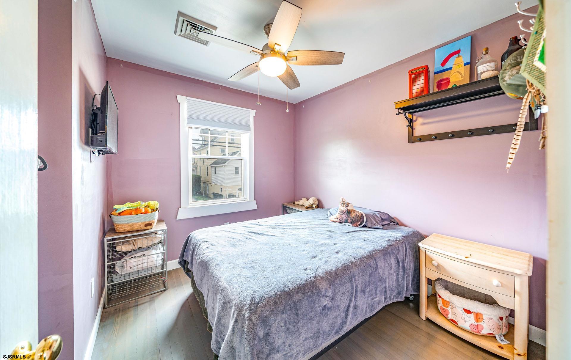 321 Central Avenue Ocean City, NJ 08226 - Photo 47 of 61 a bedroom with a bed a dresser and a chandelier