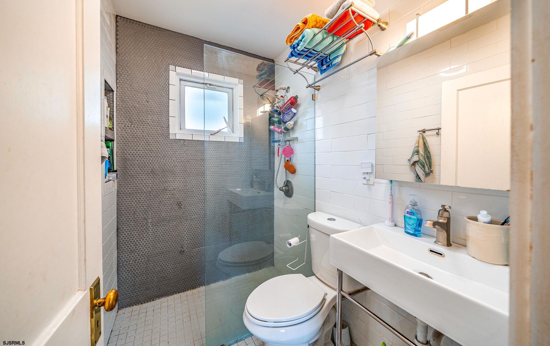 321 Central Avenue Ocean City, NJ 08226 - Photo 48 of 61 a bathroom with a sink a toilet and shower curtain