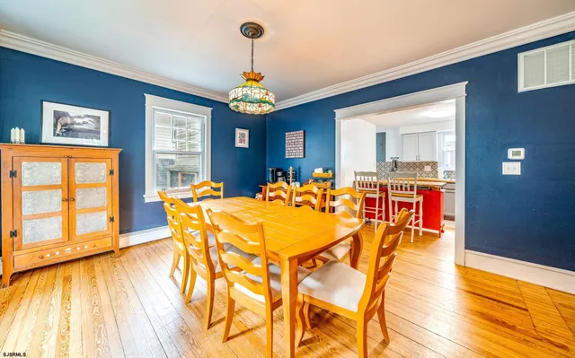 a view of a dining room with furniture a chandelier and wooden floor