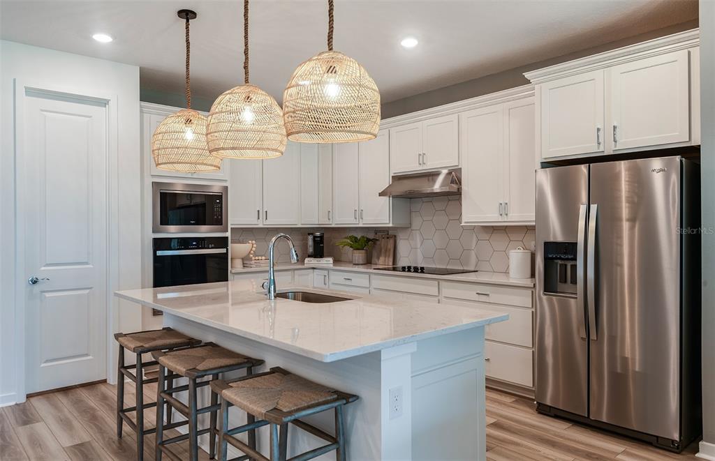 3620 Obsidian Drive Spring Hill, FL 34609 - Photo 2 of 24 a kitchen with stainless steel appliances granite countertop a sink refrigerator stove and microwave