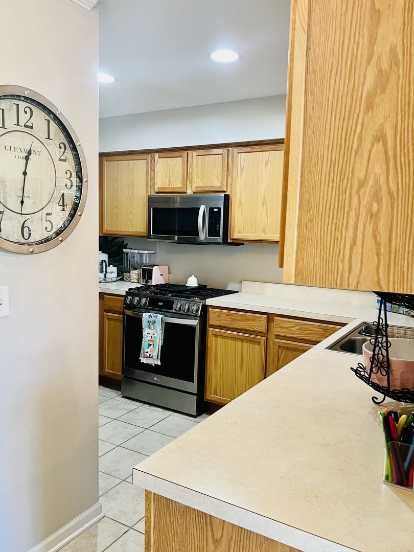 39102 Welsh Lane Beach Park, IL 60083 - Photo 9 of 24 a kitchen with stainless steel appliances granite countertop a sink a stove and a refrigerator