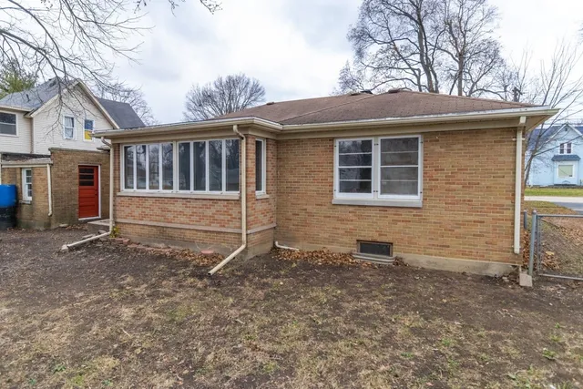 a view of a house with a yard and wooden fence
