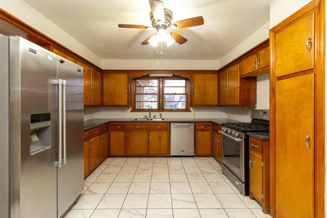 a large kitchen with stainless steel appliances granite countertop a refrigerator and a stove