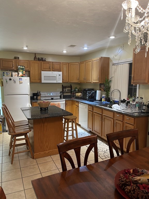 89 West Boylston Street, Unit 3 Worcester, MA 01606 - Photo 3 of 9 a kitchen with a table chairs stove and cabinets