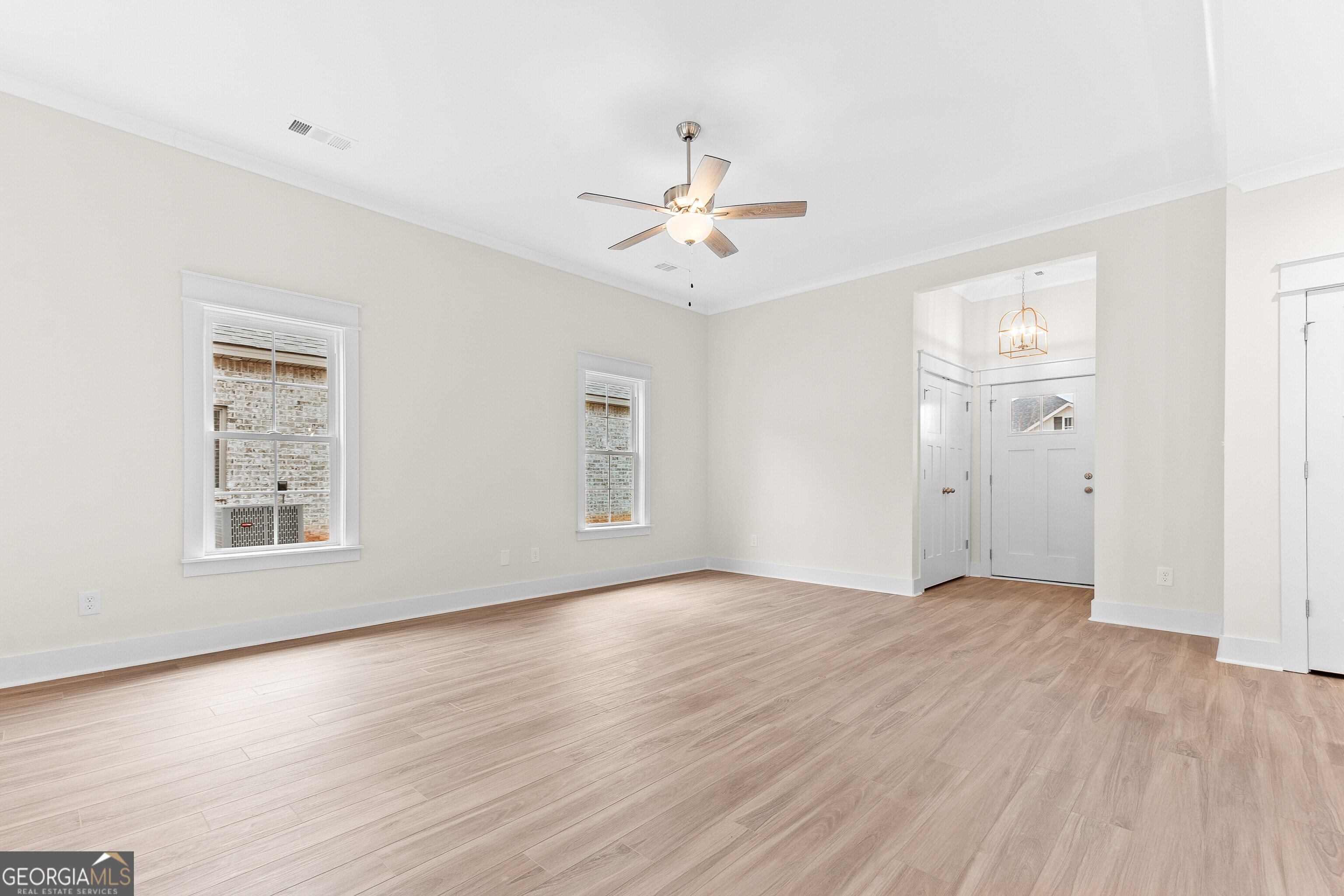 608 Bristleleaf Path Kathleen, GA 31047 - Photo 6 of 48 an empty room with wooden floor chandelier fan and windows