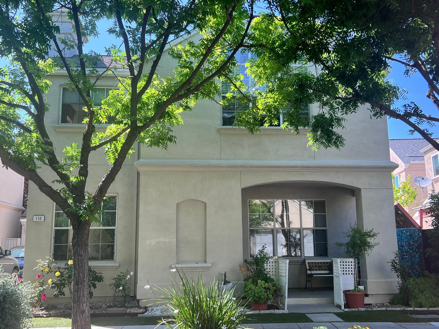 a front view of a house with a tree