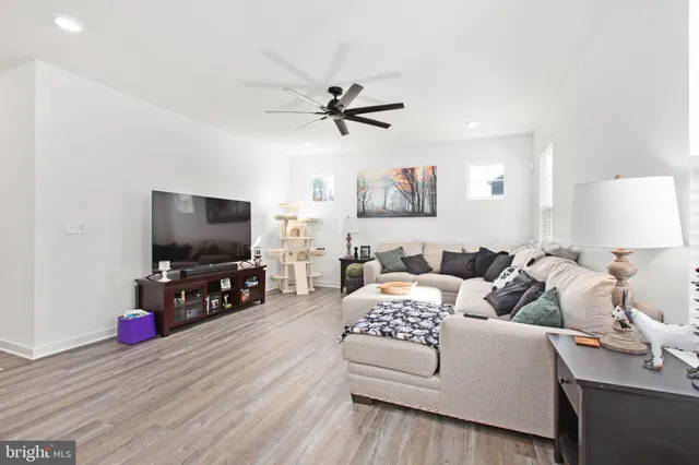 a kitchen with stainless steel appliances granite countertop a refrigerator a sink dishwasher a stove and white cabinets with wooden floor