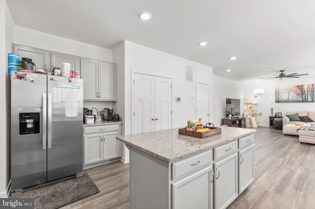 a living room with kitchen island furniture and a potted plant