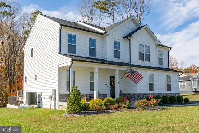 a front view of a house with a garden and yard