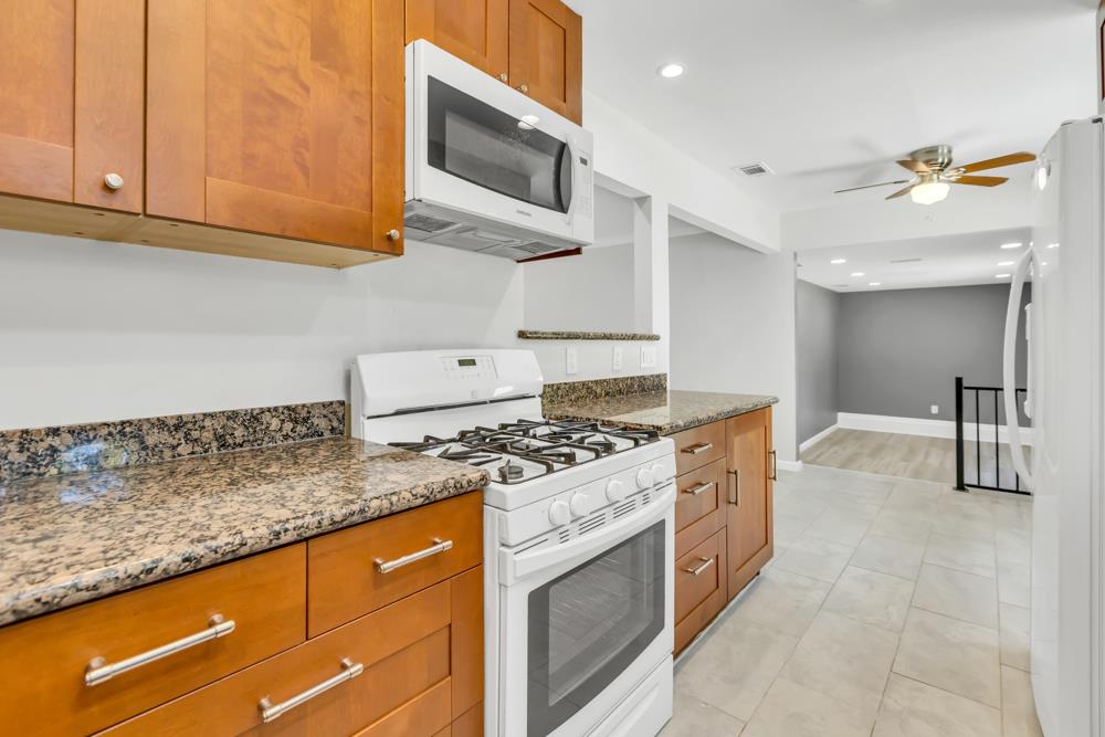 8843 Pershing Avenue Orangevale, CA 95662 - Photo 7 of 29 a kitchen with stainless steel appliances granite countertop a stove and a microwave with cabinets