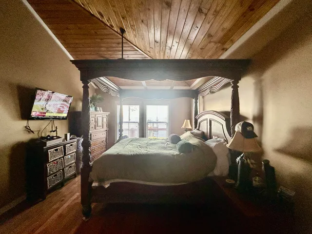 a bedroom with a bed and dresser with mirror