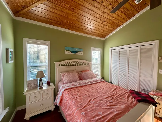 a bedroom with a large bed and wooden floor