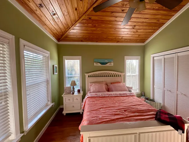 a bedroom with a large bed and wooden floor