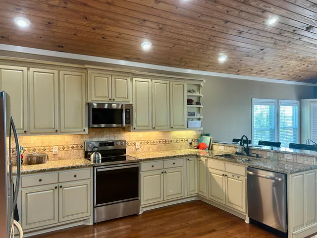 a kitchen with stainless steel appliances granite countertop a stove sink and cabinets