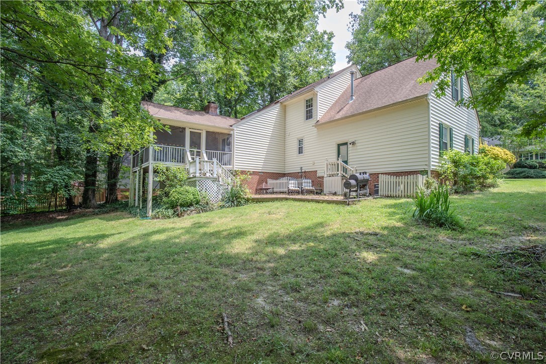 2306 Shadow Ridge Court Midlothian, VA 23112 - Photo 24 of 27 a backyard of a house with table and chairs plants and large tree