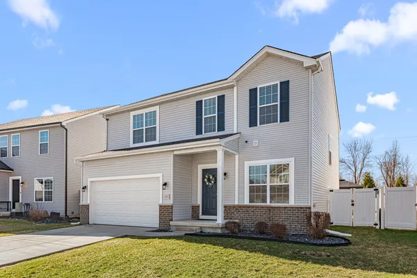 a front view of a house with a yard and garage
