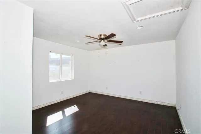 a view of an empty room with a window and a ceiling fan