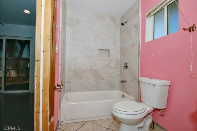 a bathroom with a granite countertop toilet a sink and a mirror