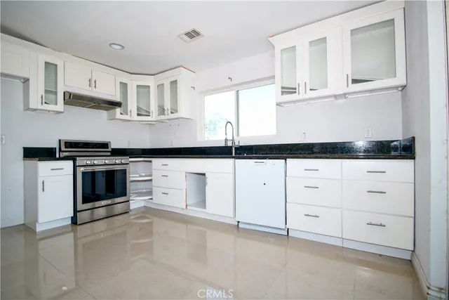 a kitchen with white cabinets and appliances