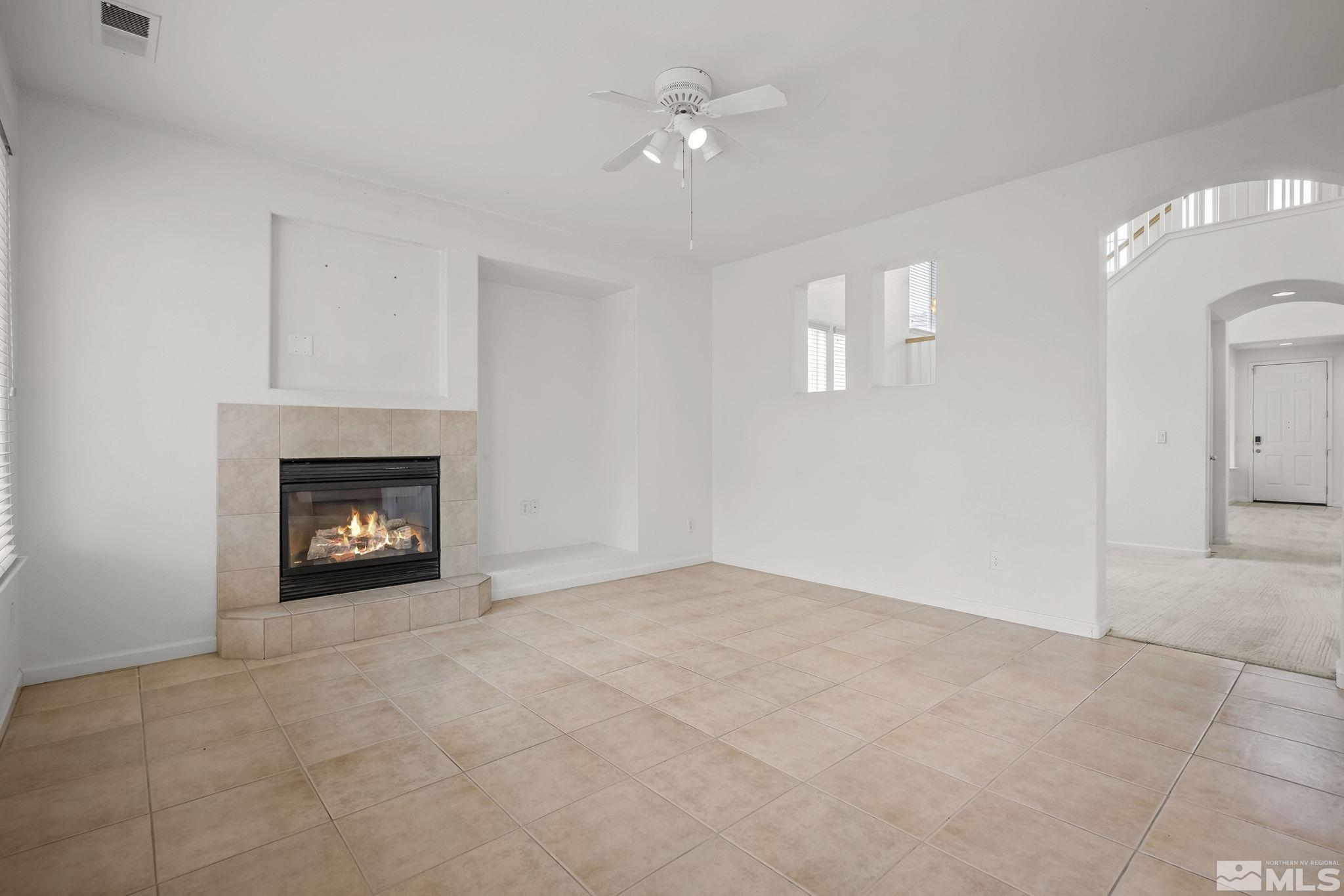 1722 Back Country Court Reno, NV 89521 - Photo 12 of 33 an empty room with a fireplace and a chandelier fan