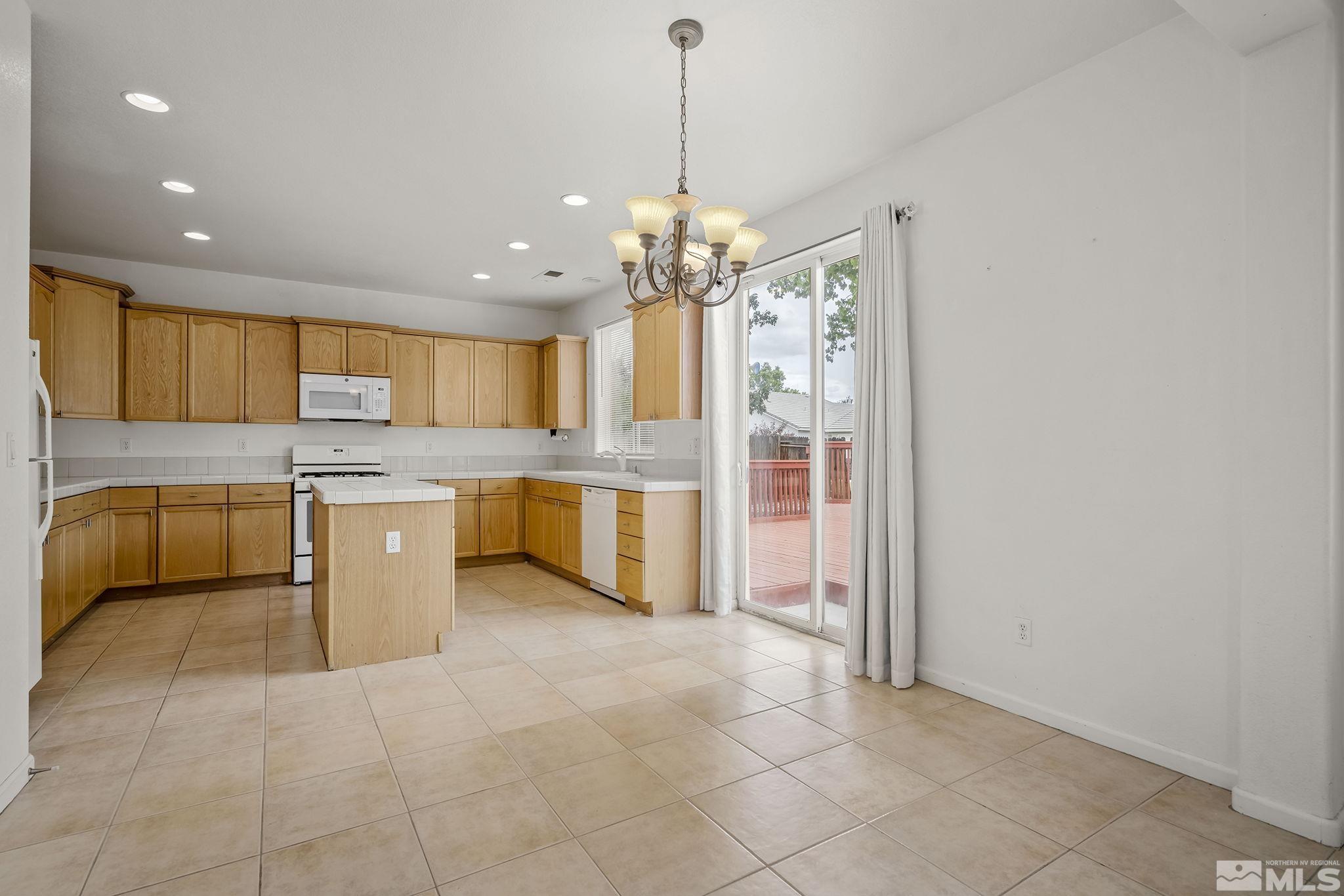 1722 Back Country Court Reno, NV 89521 - Photo 13 of 33 a large kitchen with kitchen island granite countertop a stove a sink a refrigerator and a granite counter top