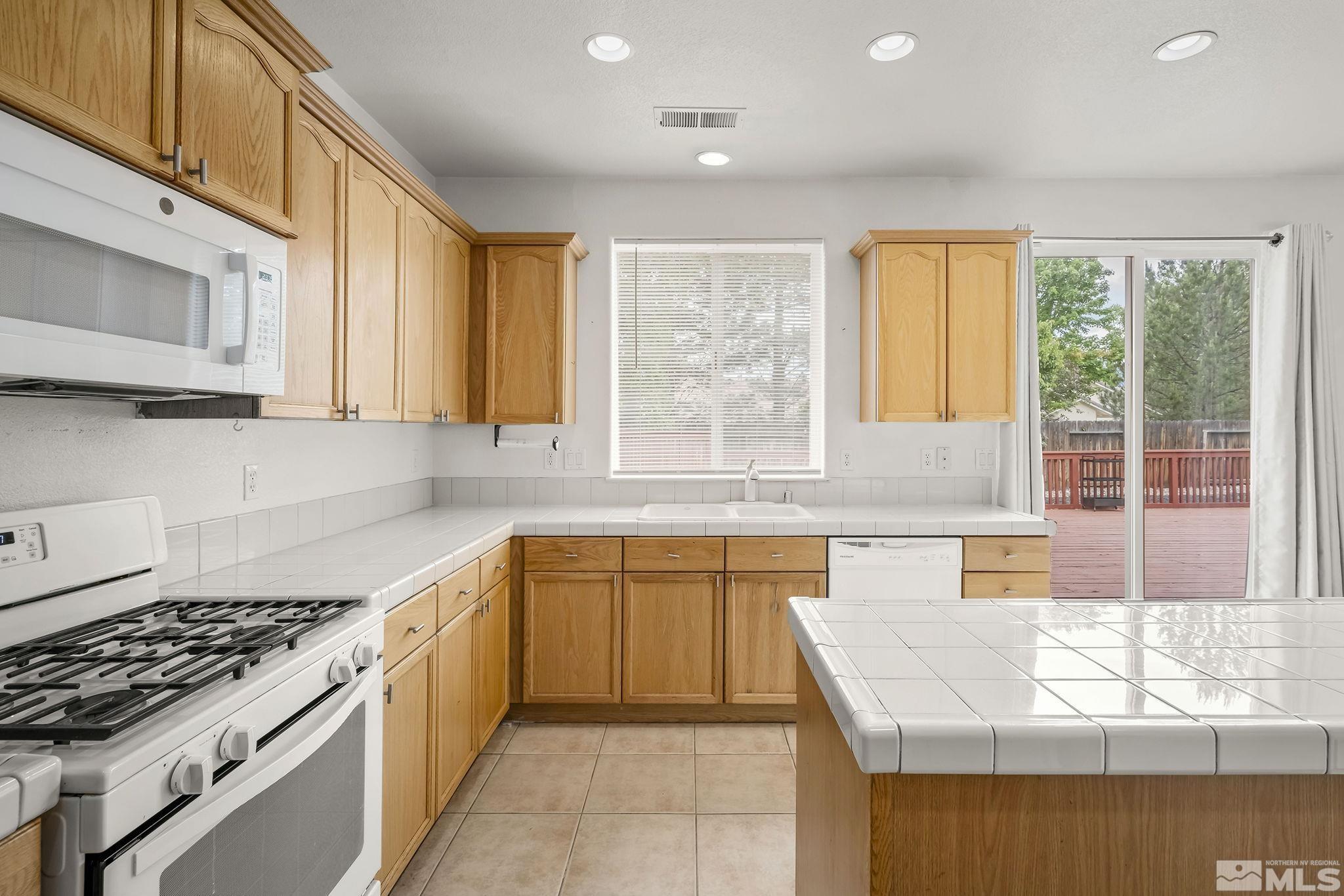 1722 Back Country Court Reno, NV 89521 - Photo 16 of 33 a kitchen with stainless steel appliances granite countertop a sink and a stove