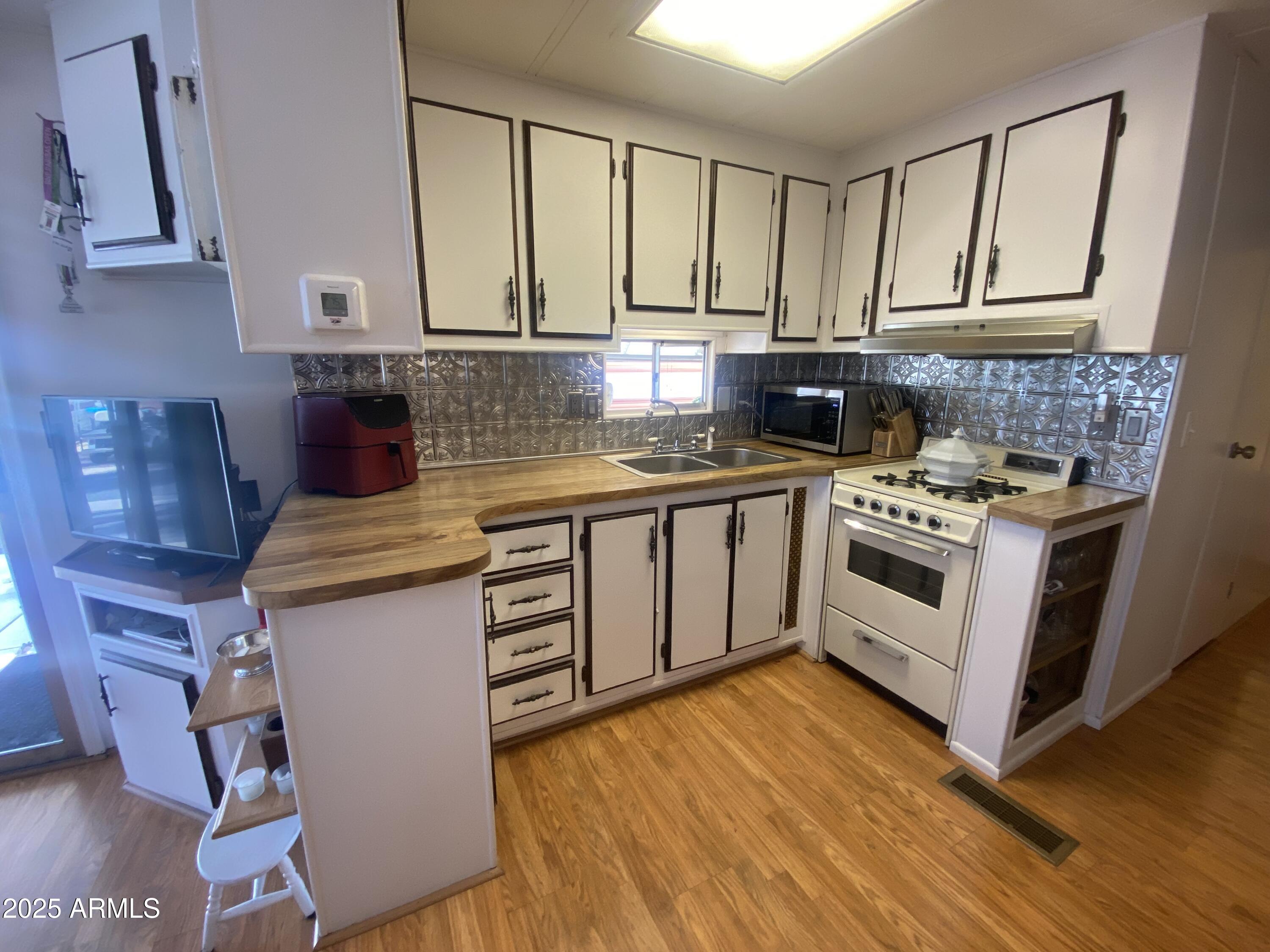 1135 South Sioux Drive Apache Junction, AZ 85119 - Photo 11 of 33 a kitchen with stainless steel appliances granite countertop a stove a sink and a microwave