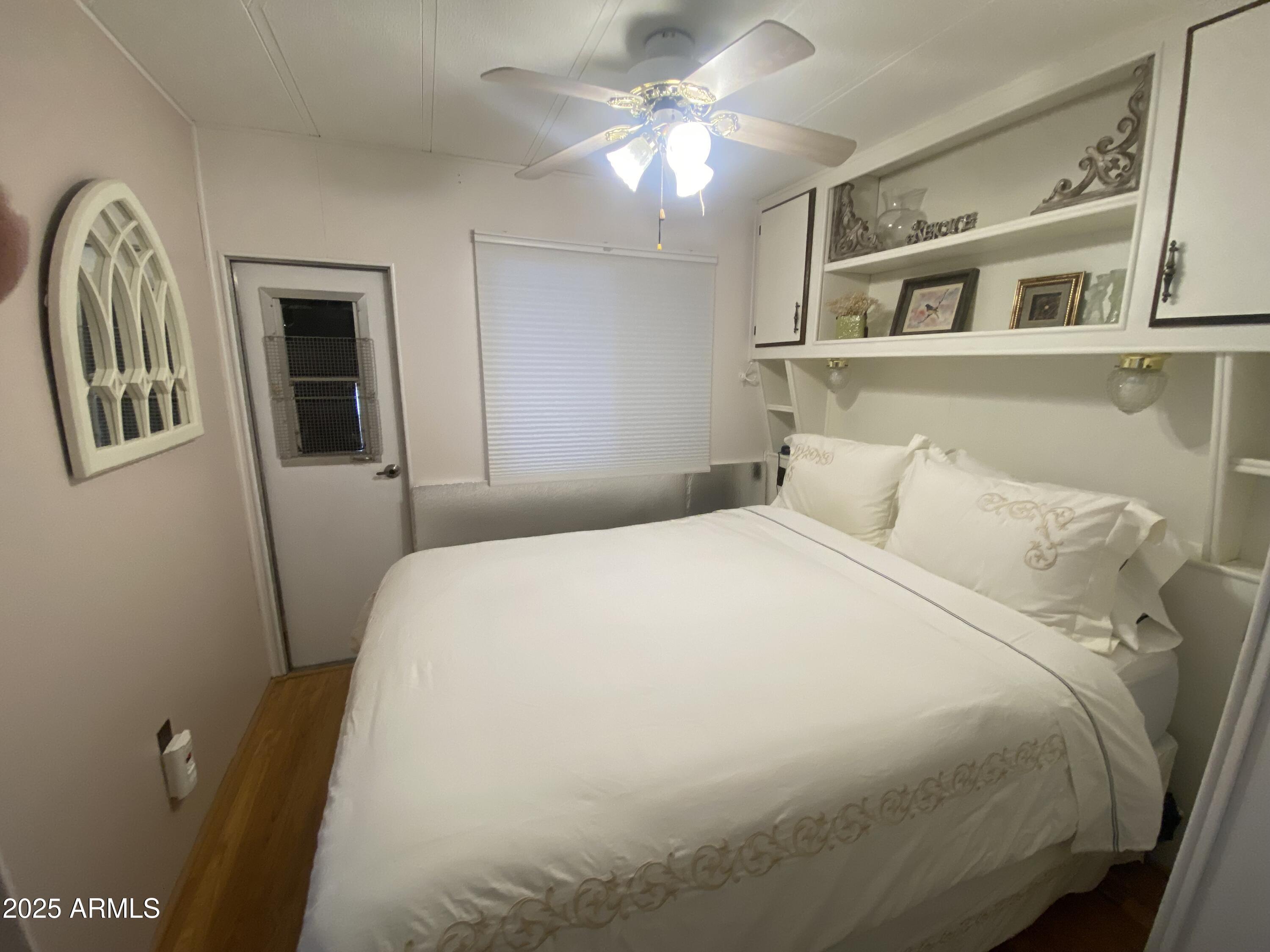 1135 South Sioux Drive Apache Junction, AZ 85119 - Photo 16 of 33 a bedroom with a bed and a chandelier