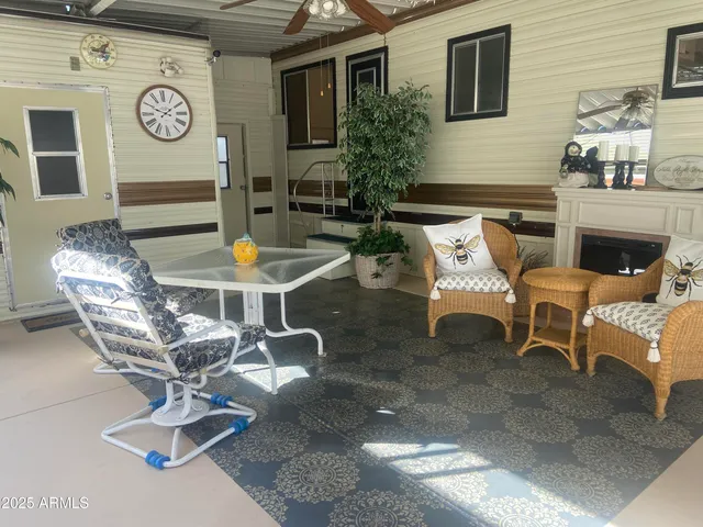 a view of a patio with table and chairs potted plants with wooden floor and fence