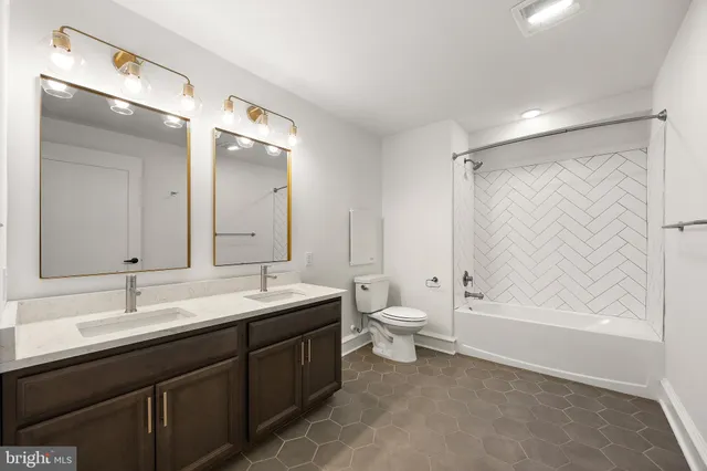 a bathroom with a double vanity sink mirror and toilet