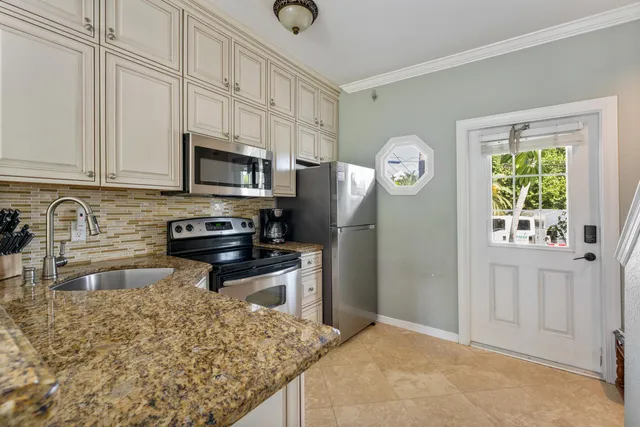 a kitchen with stainless steel appliances granite countertop a refrigerator a stove a sink and a granite counter tops