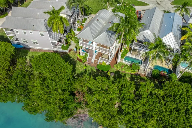 an aerial view of residential house with outdoor space and trees all around