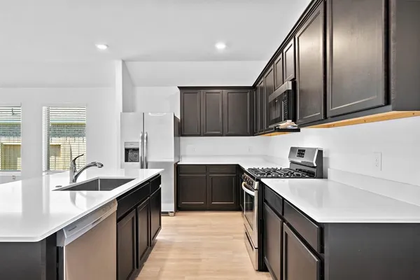 a kitchen with granite countertop stainless steel appliances and sink