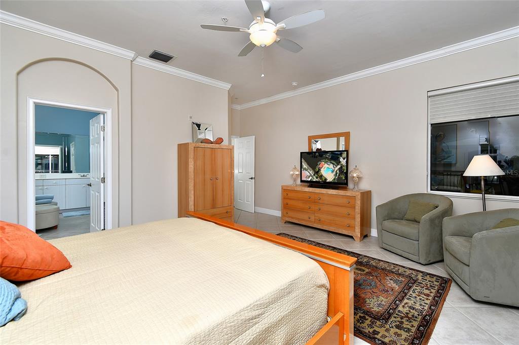 3454 Sunset Key Circle, Unit 103 Punta Gorda, FL 33955 - Photo 19 of 37 a bedroom with a bed and a flat screen tv