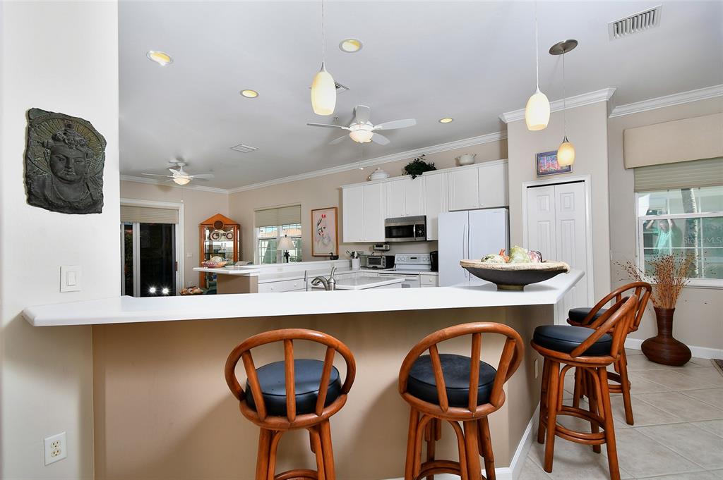 3454 Sunset Key Circle, Unit 103 Punta Gorda, FL 33955 - Photo 24 of 37 a kitchen with stainless steel appliances kitchen island granite countertop a dining table and chairs