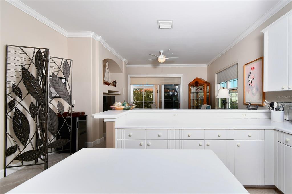 3454 Sunset Key Circle, Unit 103 Punta Gorda, FL 33955 - Photo 27 of 37 a living room with stainless steel appliances kitchen island granite countertop a refrigerator a sink a stove and white cabinets with wooden floor