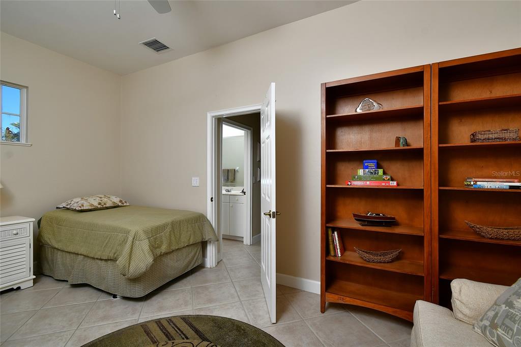 3454 Sunset Key Circle, Unit 103 Punta Gorda, FL 33955 - Photo 9 of 37 a bedroom with a bed and a shelf