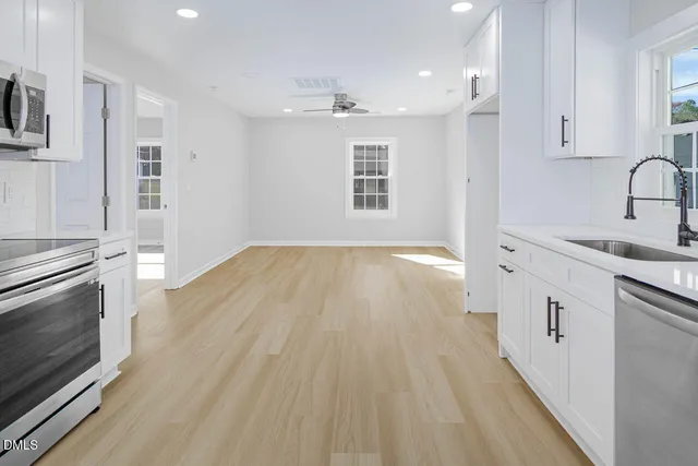 a view of a kitchen with wooden floor and electronic appliances