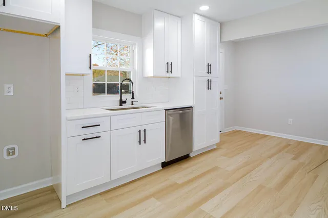 a kitchen with a sink cabinets and wooden floor