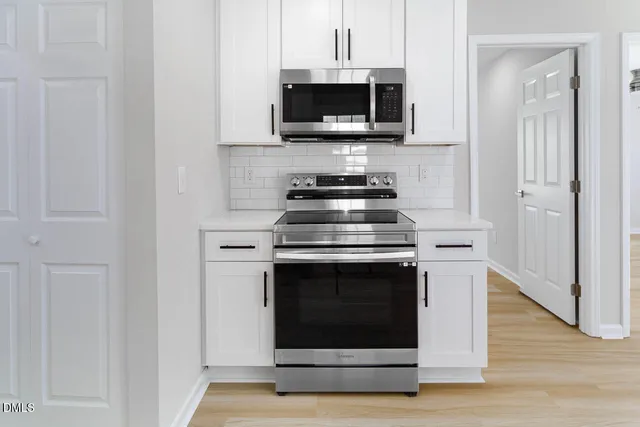 a kitchen with stainless steel appliances a stove and a microwave
