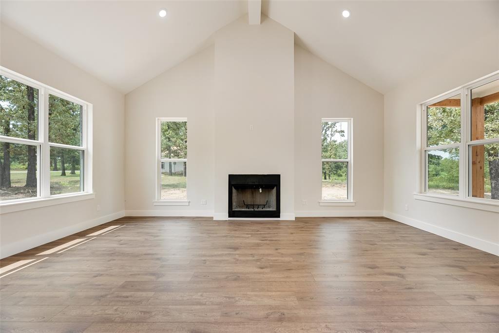 322 Rs Co Road Alba, TX 75410 - Photo 7 of 37 Unfurnished living room with high vaulted ceiling, light wood finished floors, a fireplace, beamed ceiling, and recessed lighting